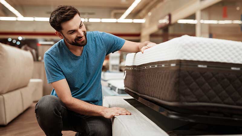 homem a experimentar colchão de espuma viscoelástica